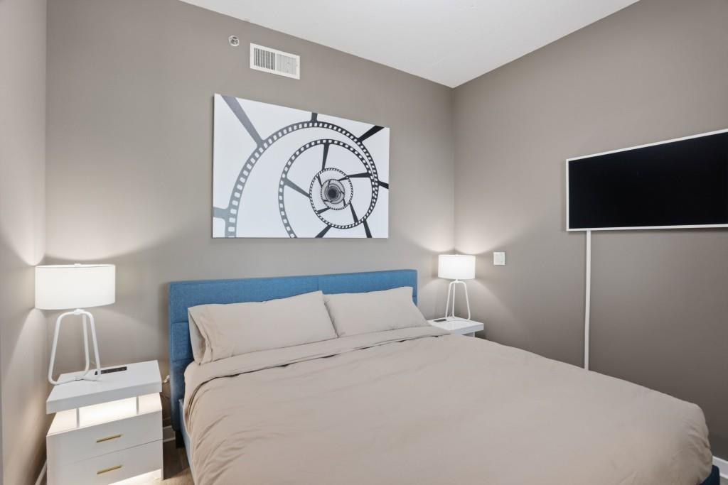 361 17th Street Northwest, Unit 1720 Atlanta, GA 30363 - Photo 12 of 38 a bedroom with a bed and a flat screen tv