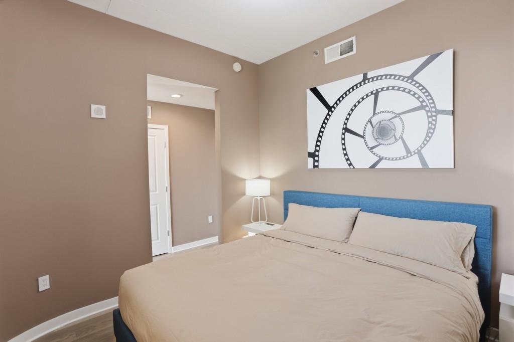 361 17th Street Northwest, Unit 1720 Atlanta, GA 30363 - Photo 14 of 38 a bedroom with a bed and a painting on the wall