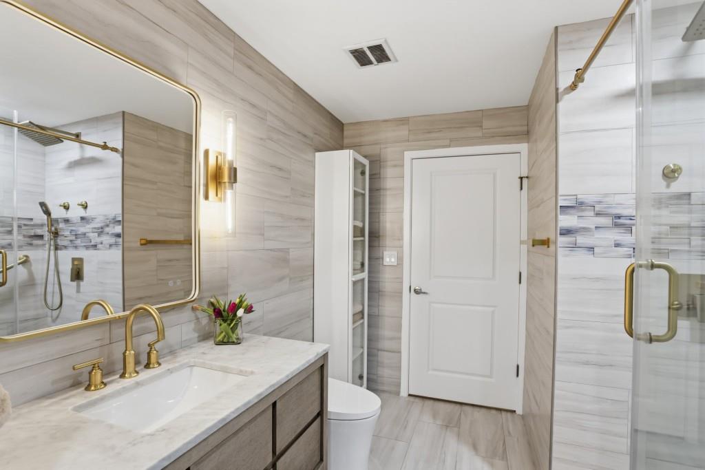 361 17th Street Northwest, Unit 1720 Atlanta, GA 30363 - Photo 16 of 38 a bathroom with a granite countertop sink a toilet and shower