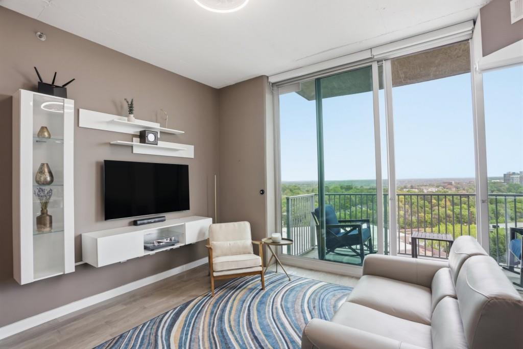 361 17th Street Northwest, Unit 1720 Atlanta, GA 30363 - Photo 3 of 38 a living room with furniture a flat screen tv and a floor to ceiling window