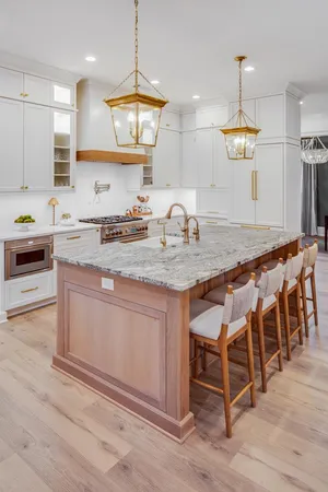 a kitchen with kitchen island granite countertop a sink a stove a dining table and chairs