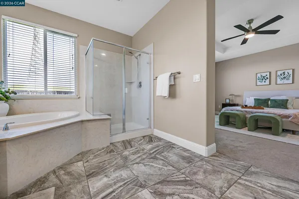 a bathroom with a tub a sink and a large mirror