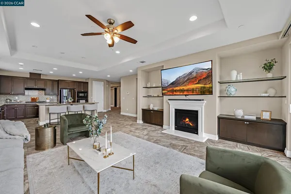 a living room with furniture a fireplace and kitchen view
