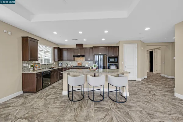 a kitchen with stainless steel appliances kitchen island granite countertop a sink and cabinets
