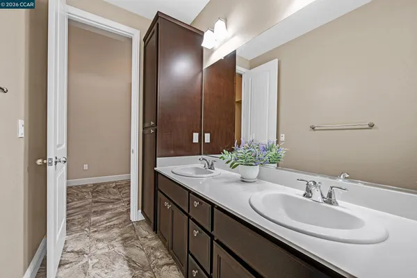 a bathroom with double vanity sinks and a mirror