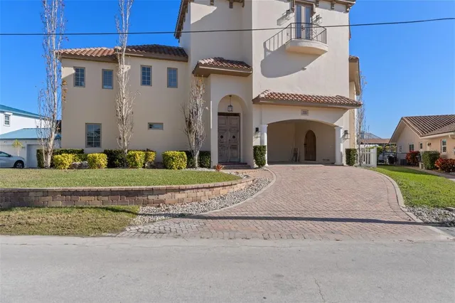 a view of a white house with a yard and large parking space
