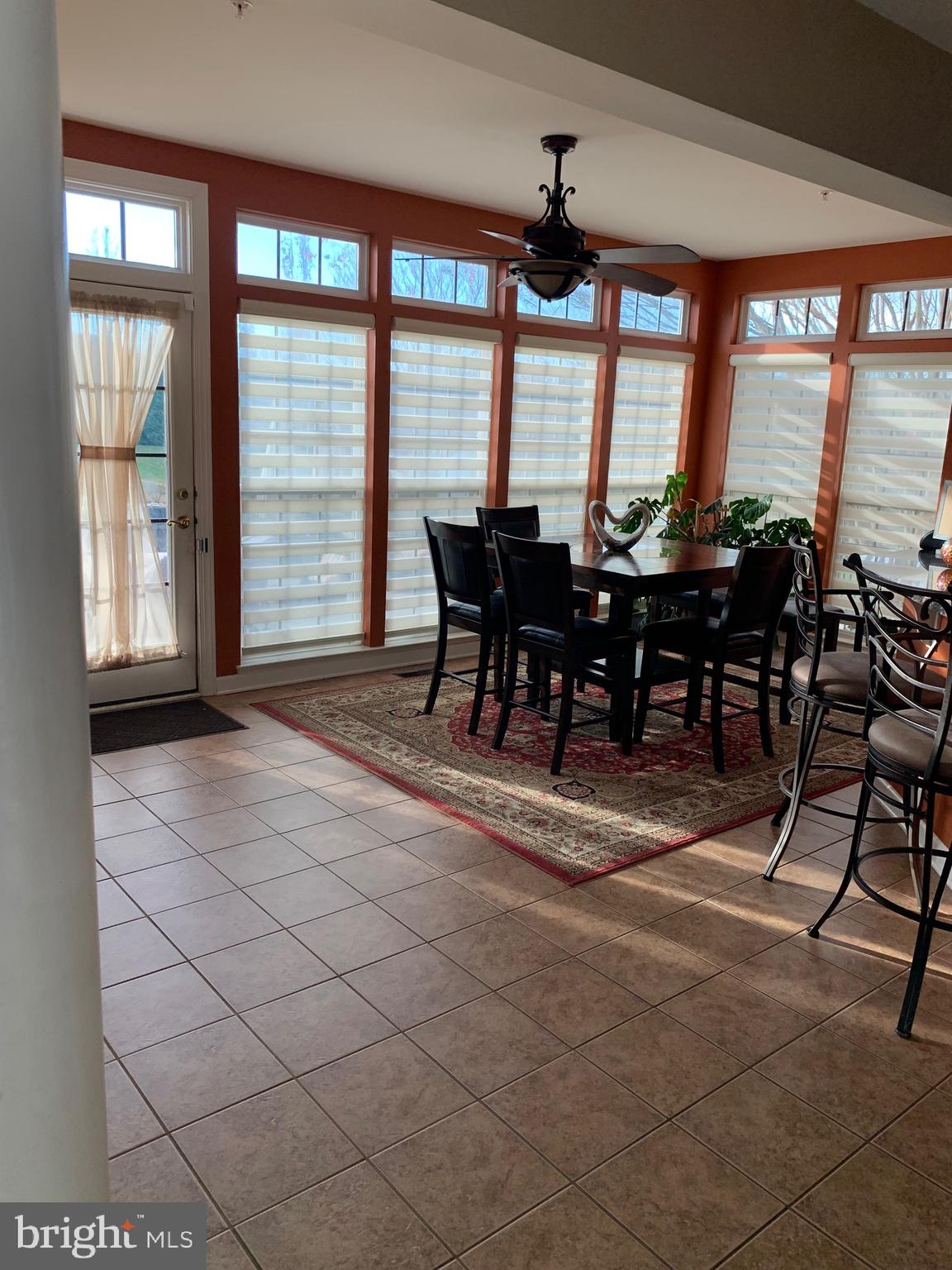 14205 Derby Ridge Road Bowie, MD 20721 - Photo 12 of 53 a view of a dining room with furniture large windows and wooden floor