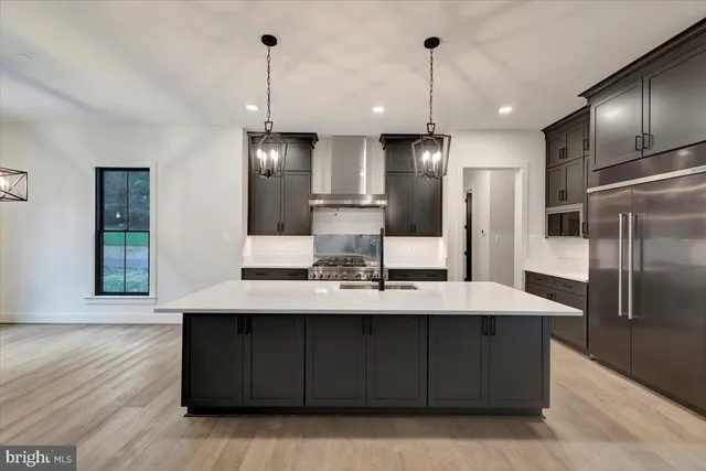 a kitchen with stainless steel appliances granite countertop a refrigerator and a stove top oven