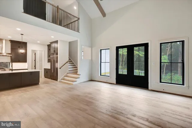 a kitchen with a sink chandelier and wooden floor