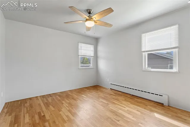 a view of a livingroom with wooden floor and a ceiling fan