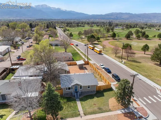 an aerial view of a house with a mountain