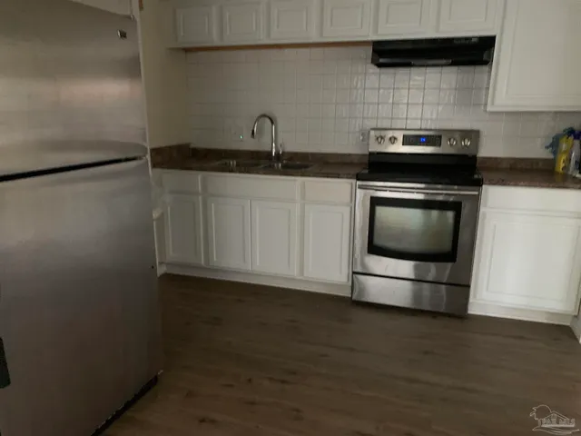 a kitchen with granite countertop a sink and a stove