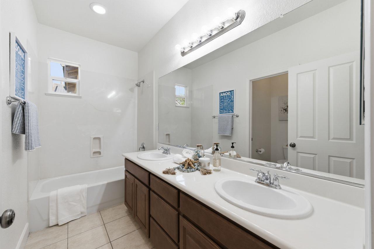 698 West Rico Way Tracy, CA 95391 - Photo 33 of 38 a spacious bathroom with a double vanity sink a large mirror and a bathtub