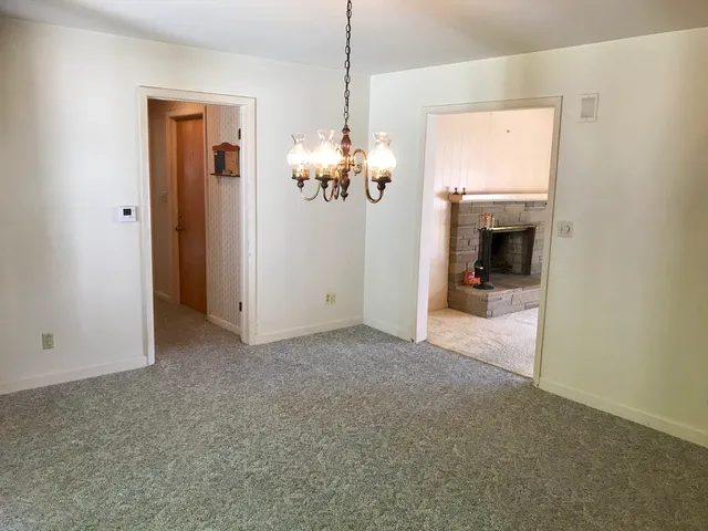 a view of a room with a chandelier fan and a window