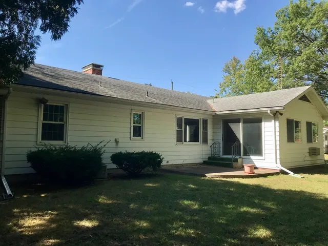 a view of a house with backyard and sitting area