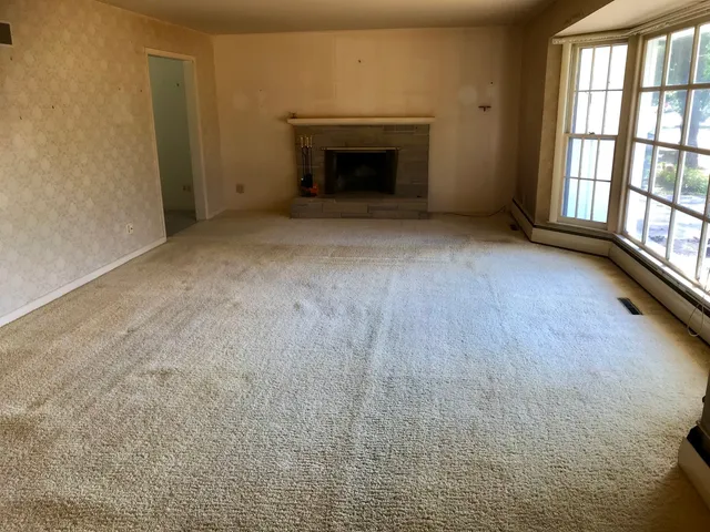 a view of an empty room with a fireplace and a window