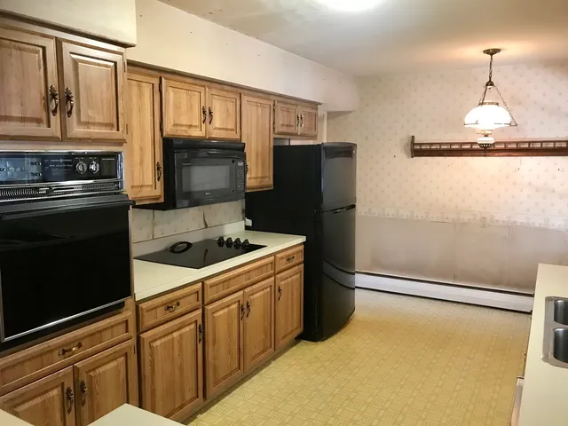 a kitchen with stainless steel appliances granite countertop a refrigerator a stove and a sink