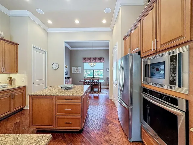 a living room with stainless steel appliances kitchen island granite countertop furniture wooden floor and a window