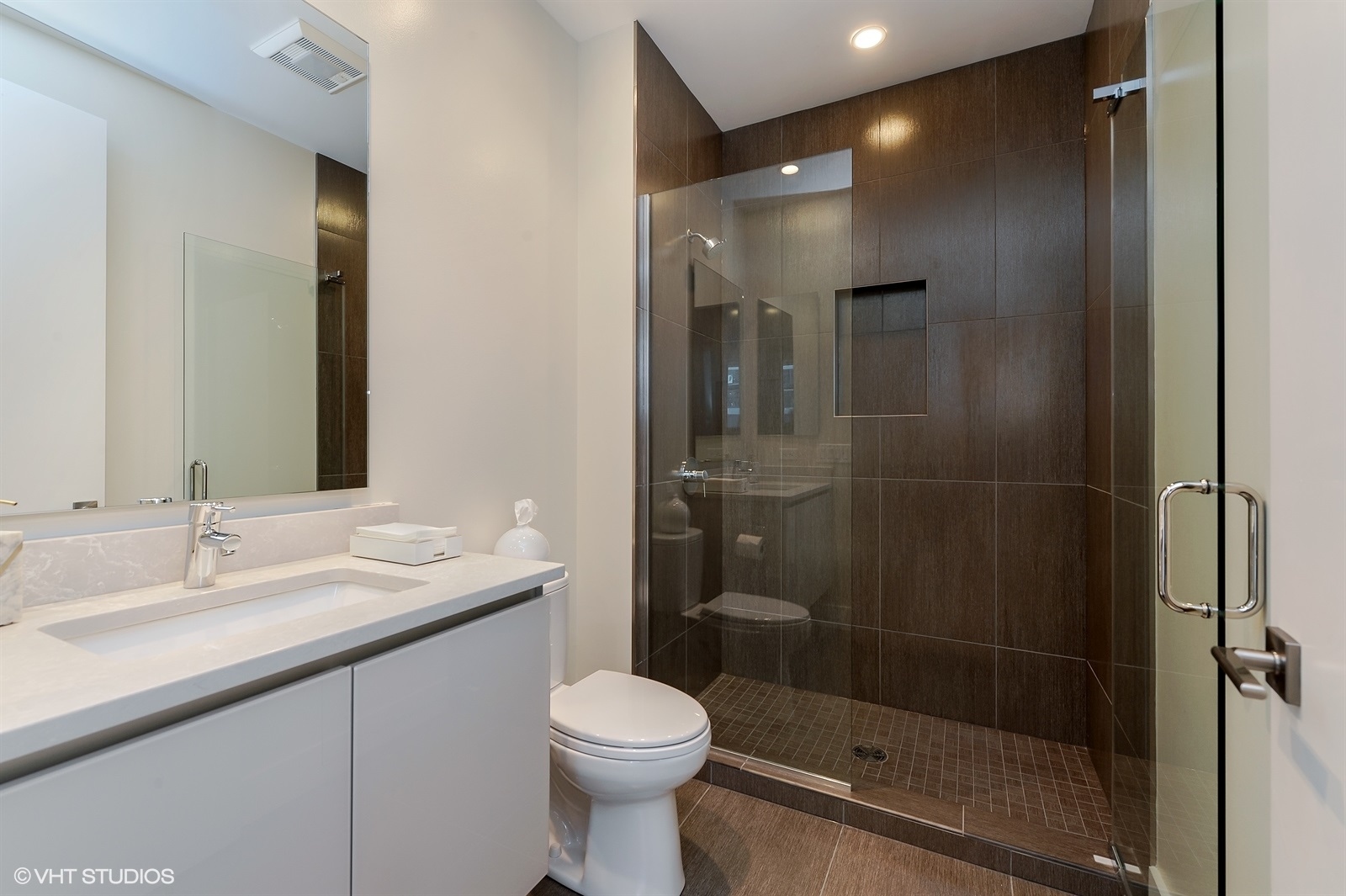 367 West Locust Street, Unit 606 Chicago, IL 60610 - Photo 18 of 24 a bathroom with a shower sink vanity and toilet
