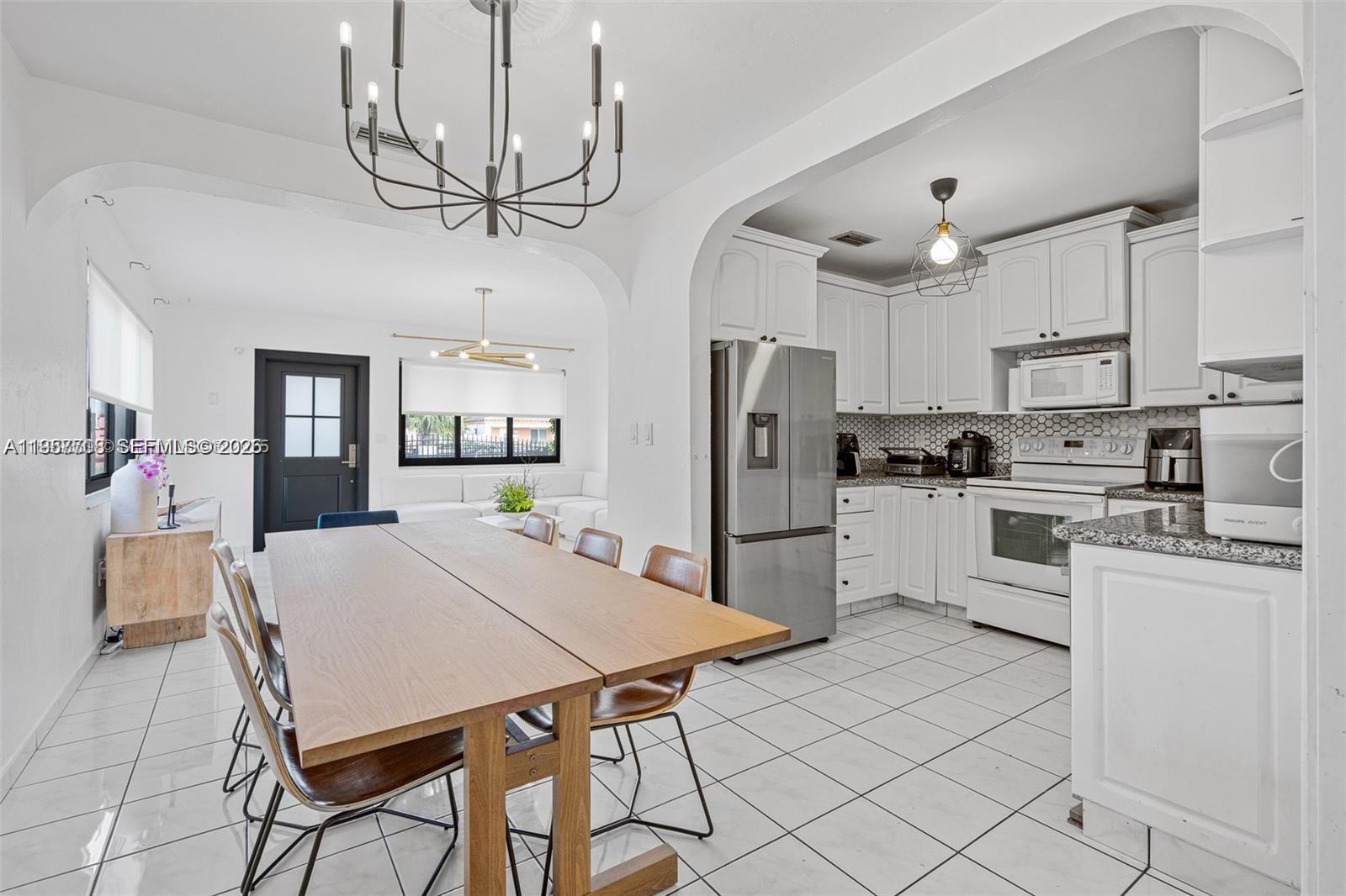 6418 Southwest 39th Terrace Miami, FL 33155 - Photo 8 of 24 a kitchen with stainless steel appliances a table chairs refrigerator and cabinets