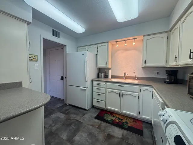 a kitchen with a refrigerator and cabinets