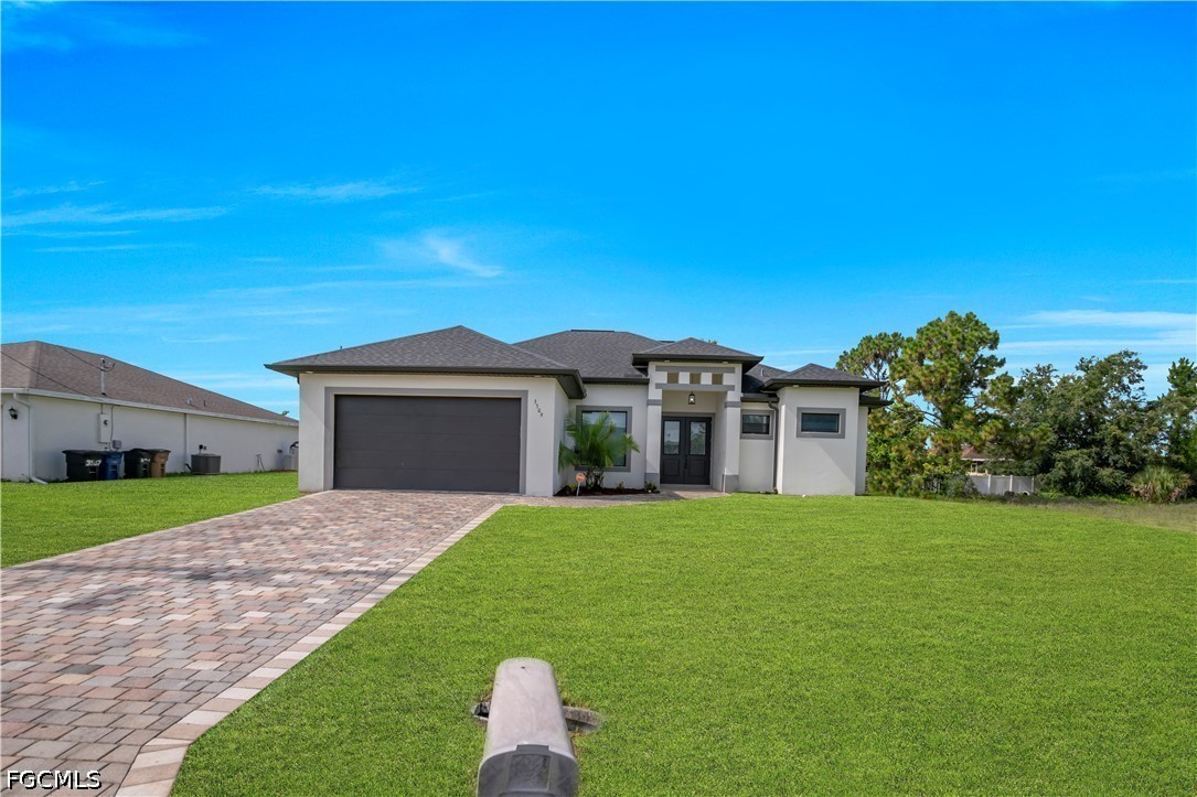 3509 38th Street Southwest Lehigh Acres, FL 33976 - Photo 3 of 47 a front view of a house with a yard and garage