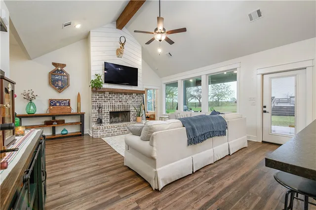 a living room with furniture a flat screen tv and a fireplace