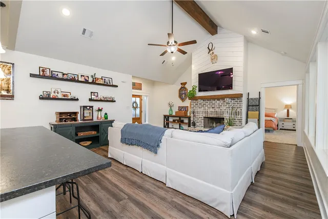 a living room with furniture a flat screen tv and a fireplace