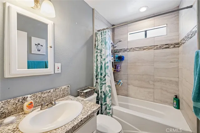 a bedroom with a large bed and a flat tv screen