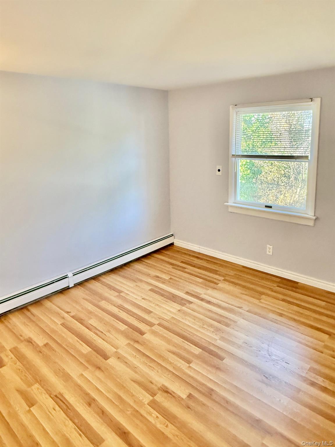 10 Revere Road Port Washington, NY 11050 - Photo 12 of 17 an empty room with wooden floor and windows