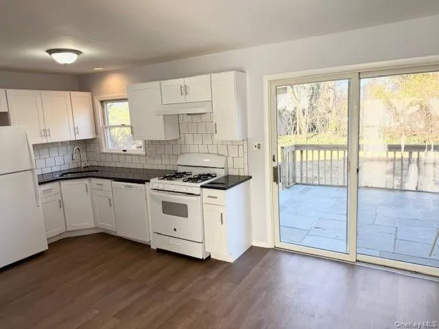a kitchen with granite countertop white cabinets and white appliances