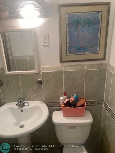 281 Northwest 52nd Street Miami, FL 33127 - Photo 27 of 28 a bathroom with a toilet sink and mirror