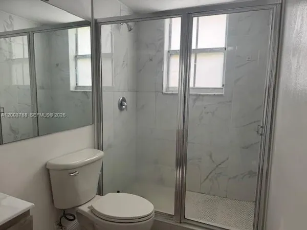 a white toilet sitting next to a bathroom sink