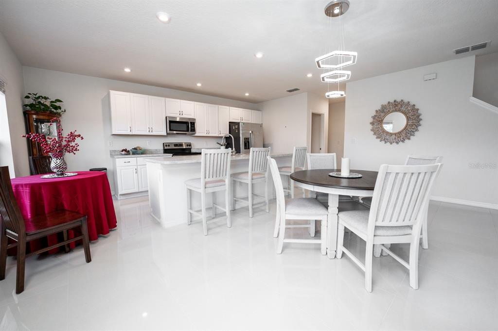 458 Hamlet Loop Davenport, FL 33837 - Photo 11 of 19 a view of kitchen with dining table and chairs