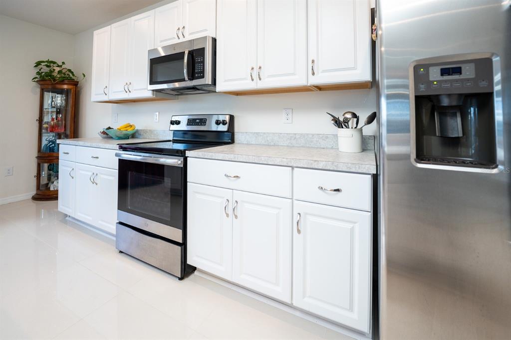 458 Hamlet Loop Davenport, FL 33837 - Photo 13 of 19 a kitchen with stainless steel appliances granite countertop white cabinets and a stove