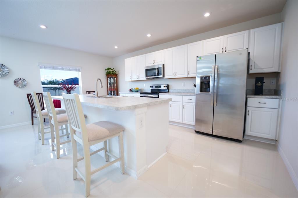 458 Hamlet Loop Davenport, FL 33837 - Photo 14 of 19 a kitchen with stainless steel appliances a refrigerator sink and cabinets