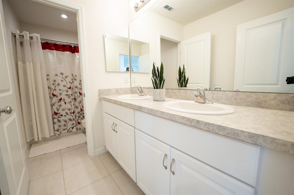 458 Hamlet Loop Davenport, FL 33837 - Photo 4 of 19 a bathroom with a granite countertop sink a shower and a mirror