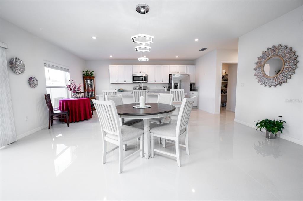 458 Hamlet Loop Davenport, FL 33837 - Photo 10 of 19 a dining room with furniture and a chandelier