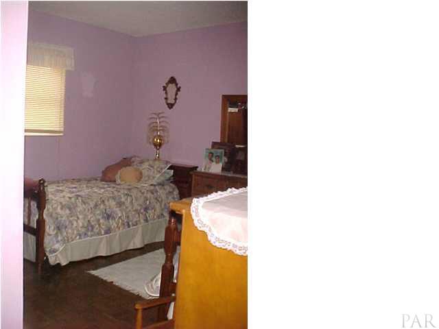 6415 Hampton Road Pensacola, FL 32505 - Photo 8 of 11 a bedroom with a bed and a table in it