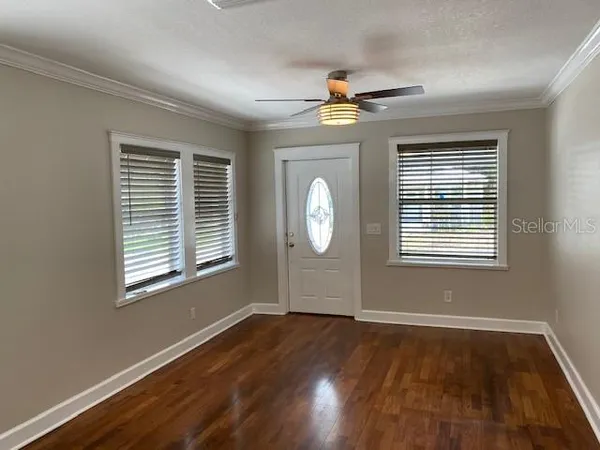a view of empty room with wooden floor and fan