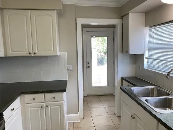 a kitchen with granite countertop a sink dishwasher a stove and a refrigerator