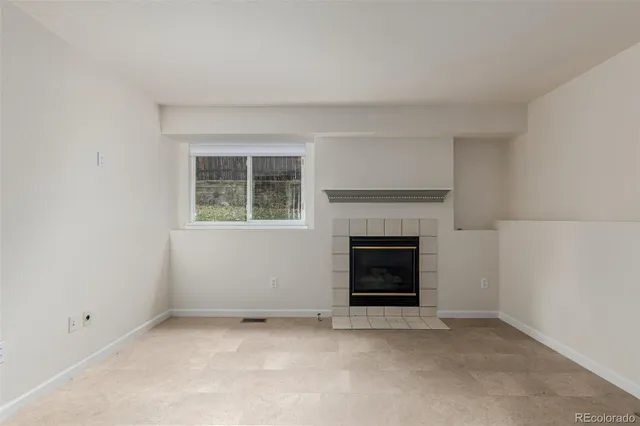 an empty room with a fireplace and window