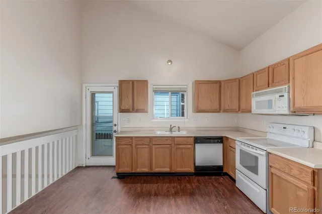 a kitchen with a sink cabinets wooden floor and stainless steel appliances