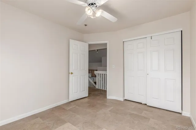 an empty room with a ceiling fan and closet area