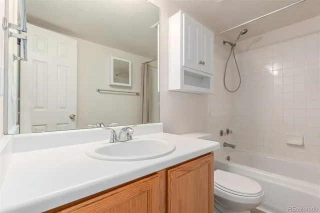 a bathroom with a granite countertop sink a toilet and shower