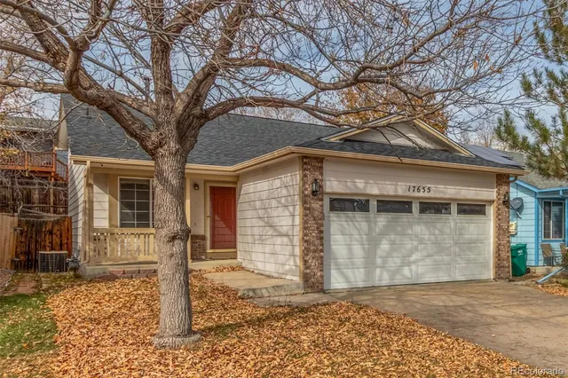 a front view of a house with a tree