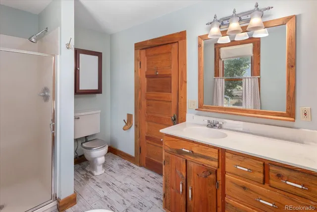 a bathroom with a sink a toilet and shower