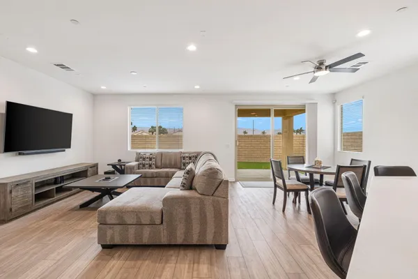 a living room with stainless steel appliances kitchen island granite countertop wooden floor a couch and a window