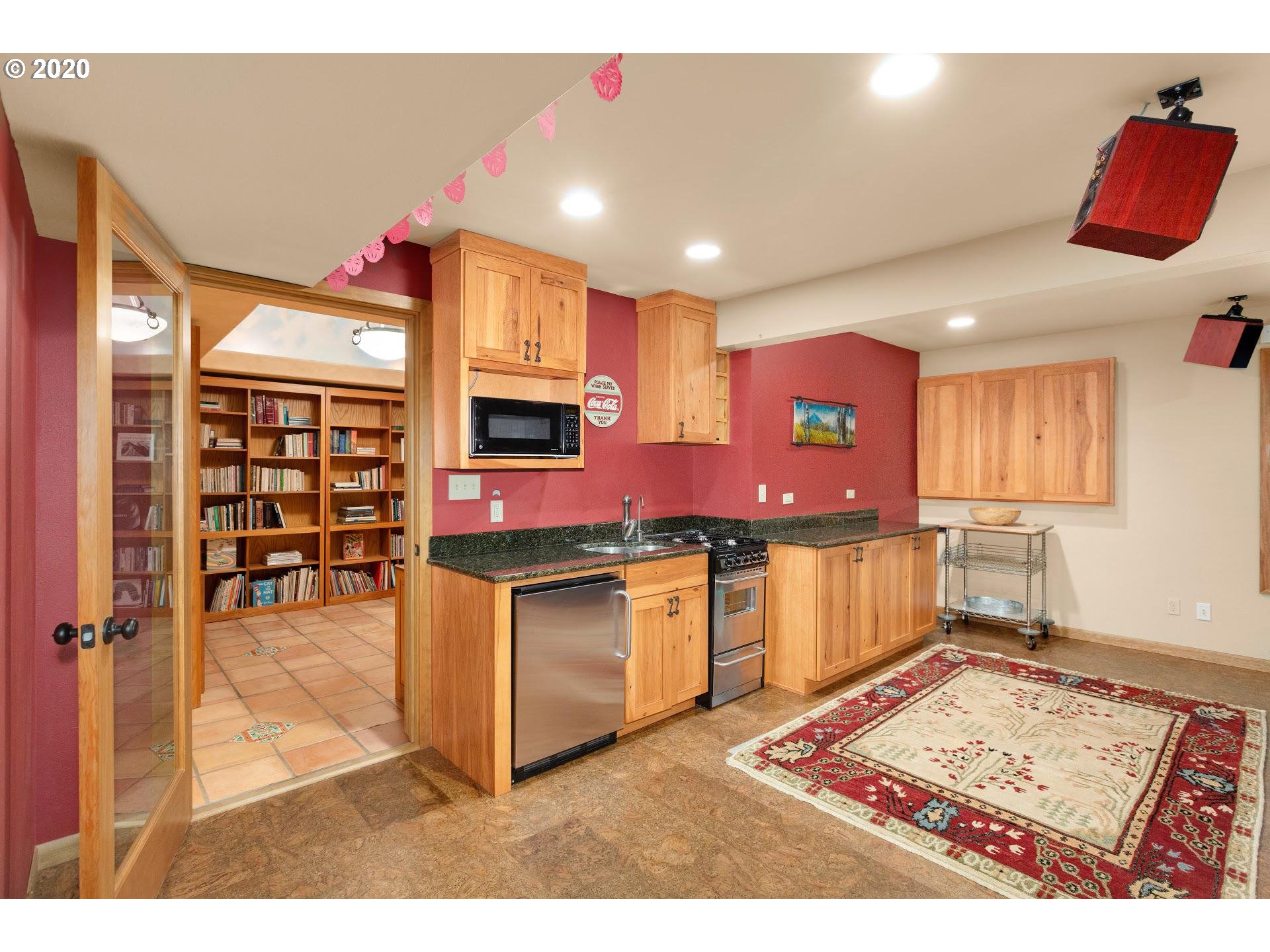 2654 Southwest Fairmount Boulevard Portland, OR 97239 - Photo 21 of 32 a kitchen with stainless steel appliances kitchen island granite countertop a stove a sink and a microwave
