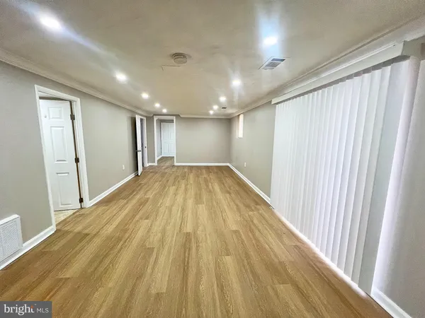 an empty room with wooden floor and entrance